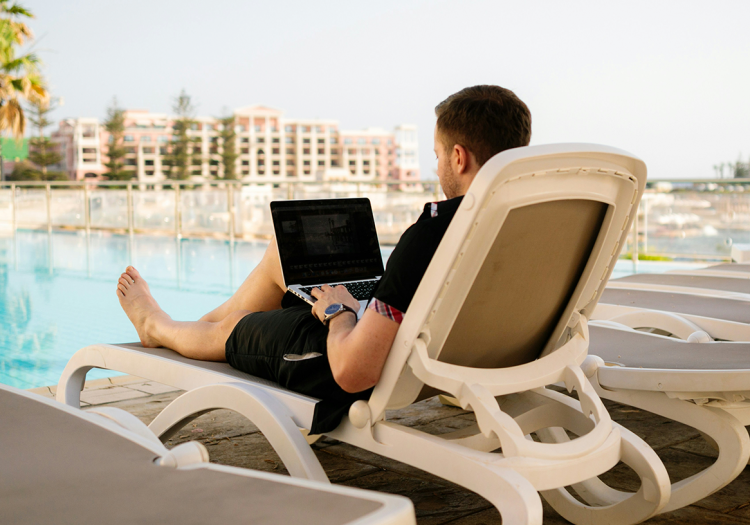 O nômade digital e sua relação com o trabalho remoto l homem em uma cadeira sentado na beira de uma piscina l Corporis Brasil