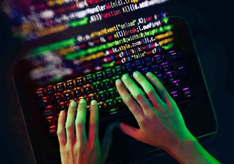 Mão digitando códigos no teclado.